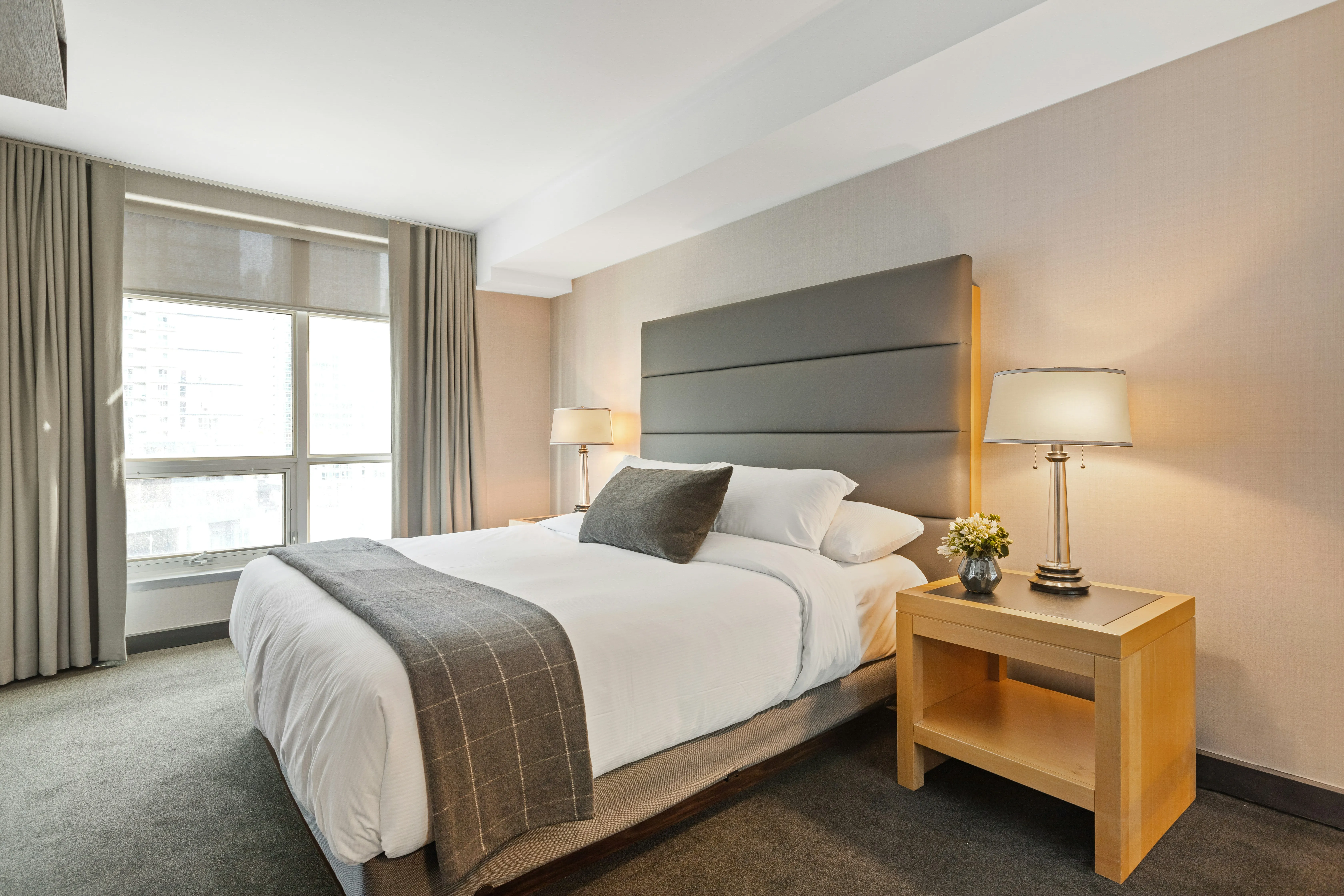 Frisch hergerichtetes Hotelzimmer mit gemachtem Bett und Tageslicht — typische Hotelfläche für tägliches Housekeeping